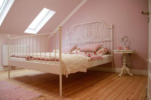 1 dormitorio con cama blanca y ventana en Petite Maison, en Püttlingen