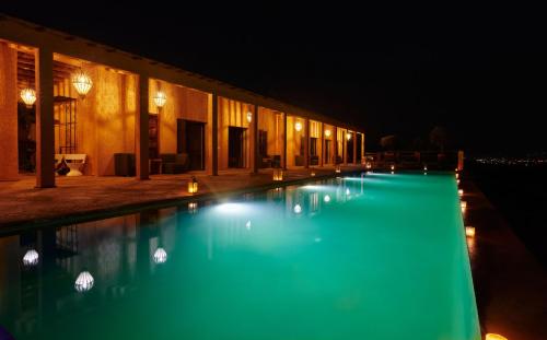 a swimming pool lit up at night at Dar Imiri in Ourika