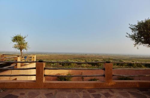 a wooden fence with a view of a field at Dar Imiri in Ourika