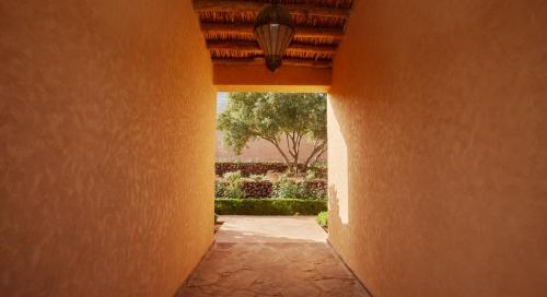 an empty hallway with an orange wall and a tree at Dar Imiri in Ourika