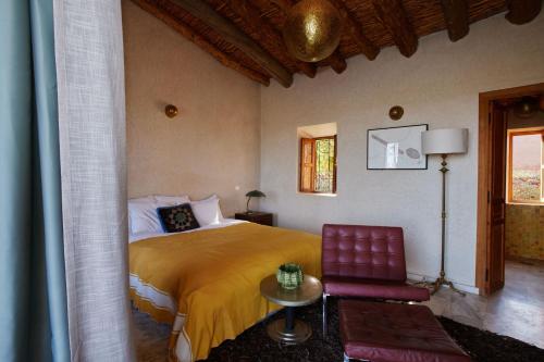a bedroom with a bed and a red chair at Dar Imiri in Ourika