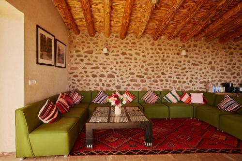 a living room with a green couch and a table at Dar Imiri in Ourika