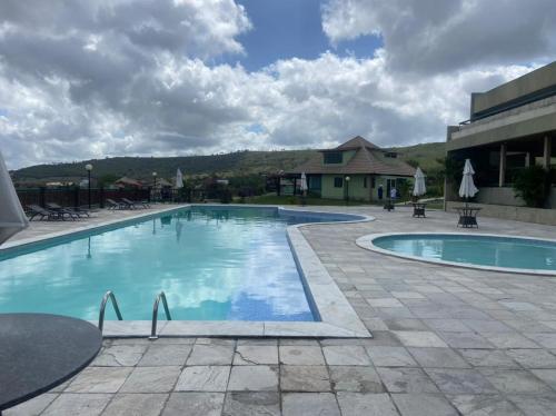 a large swimming pool in a courtyard with a building at FLAT VILLA MONTE CASTELO in Bezerros