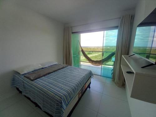 a bedroom with a bed and a desk and a window at FLAT VILLA MONTE CASTELO in Bezerros
