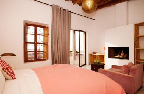 a bedroom with a bed and a chair and window at Dar Imiri in Ourika