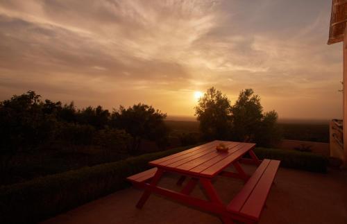 a picnic table with the sunset in the background at Dar Imiri in Ourika