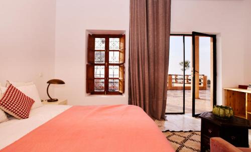 a bedroom with a bed and a large window at Dar Imiri in Ourika