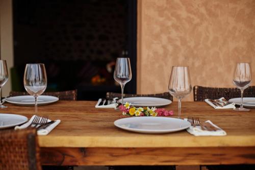 a wooden table with empty plates and wine glasses at Dar Imiri in Ourika