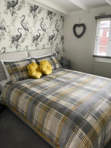 Lakeview Lodge, Builth Wells (pet friendly) في بيلث ويلز: غرفة نوم بسرير كبير مع مخدات صفراء