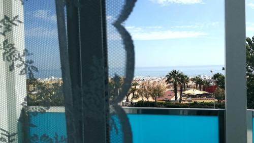 una finestra con vista su una spiaggia e sull'oceano di Hotel Spiaggia Marconi a Rimini