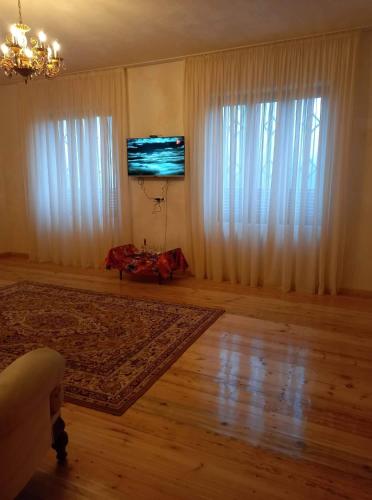 a living room with a large window and a flat screen tv at Family hotel leni in Kvareli