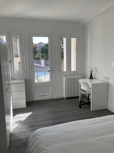 - une chambre blanche avec un lit, un bureau et des fenêtres dans l'établissement La chambre du coliving - terrasse salle de sport proche gare, à Agen