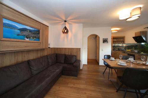 un soggiorno con divano e tavolo di Alm Appartements ZellamSee a Zell am See