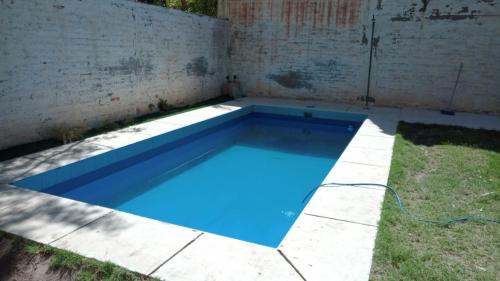 una piscina en un patio con una piscina azul en Casa Verde 2 en Godoy Cruz