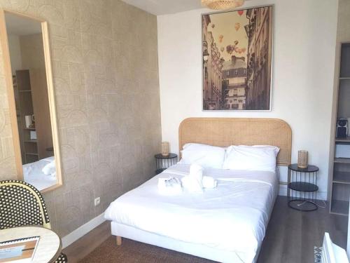 une chambre avec un lit avec des draps blancs et un miroir dans l'établissement Magnifique appartement au centre de Paris 44, à Paris