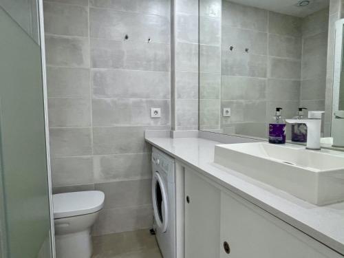 een badkamer met een wastafel, een toilet en een spiegel bij Catalonia 1-7 in L'Estartit