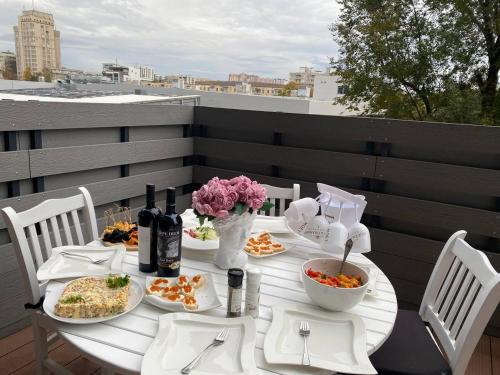 una mesa blanca con platos de comida en el balcón en Oasis, en Chişinău