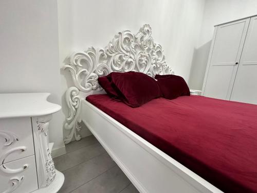 Una cama blanca con dos almohadas rojas. en Oasis, en Chişinău