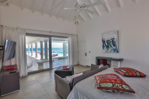 a bedroom with a bed and a view of the ocean at 5 BR Luxurious Beachfront Villa with utmost privacy in Les Terres Basses