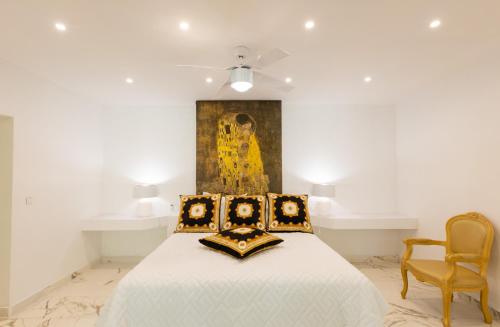 a bedroom with a bed and a painting on the wall at 5 BR Luxurious Beachfront Villa with utmost privacy in Les Terres Basses