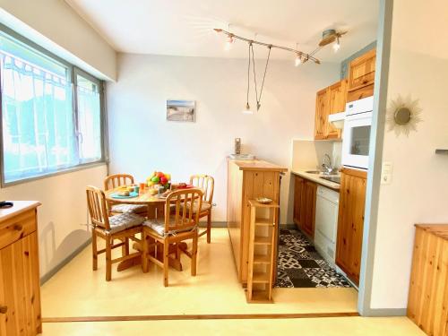a kitchen and dining room with a table and chairs at Taphao, Studio pour 4 avec parking proche mer in Courseulles-sur-Mer