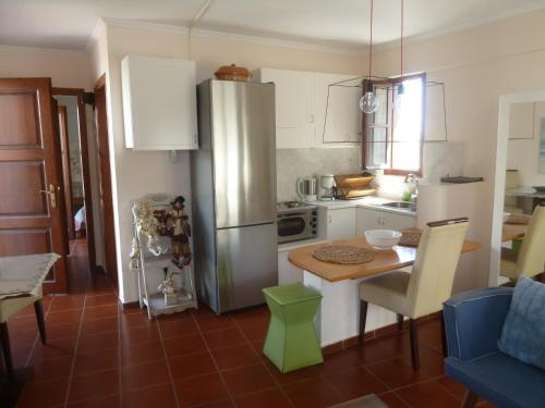 a kitchen with a stainless steel refrigerator and a table at Calergi Residence - Holidays in Crete in Atsipopoulo