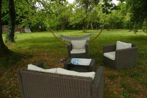 un grupo de sillas y una hamaca en un patio en EN PASSENT PAR LA LORRAINE 