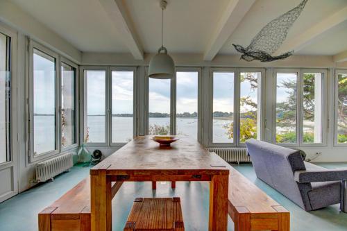 une pièce avec une table, des chaises et des fenêtres dans l'établissement Villa Dremmwel, à l'Île-aux-Moines