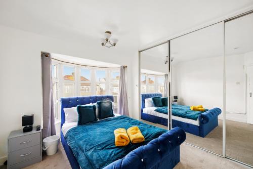 una camera con letto blu e specchio di 3bed Cozy House Parking Wifi a Welling