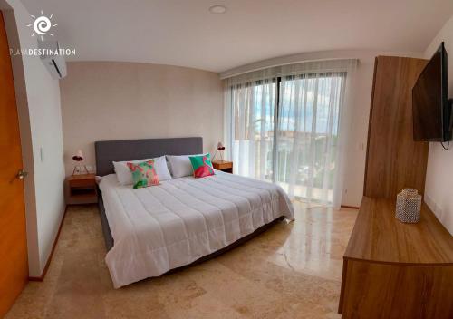 a bedroom with a large bed and a large window at Suites calle 38 in Playa del Carmen