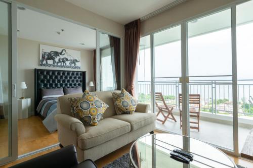 a living room with a couch and a bed at Boathouse Hua Hin Condo in Ban Bo Fai