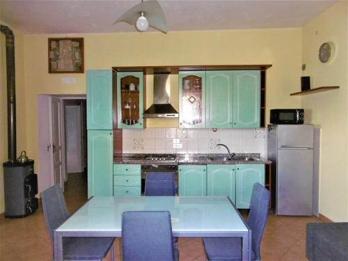 una cocina con armarios azules y una mesa con sillas en Blue Lagoon, en Amalfi