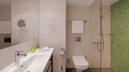 a bathroom with a sink and a toilet and a shower at Holiday Inn Frankfurt - Alte Oper, an IHG Hotel in Frankfurt