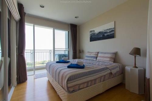 1 dormitorio con cama y ventana grande en Hi-Floor 100 Seaview 2 Brs2baths With Chicz Furniture Hua Hin Beach, en Ban Bo Fai (1)