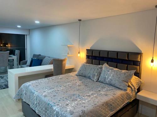 um quarto com uma cama grande e uma sala de jantar em APARTAMENTO DE LUJO EN EL CENTRO INTERNACIONAL DE BOGOTÁ, COLOMBIA. em Bogotá