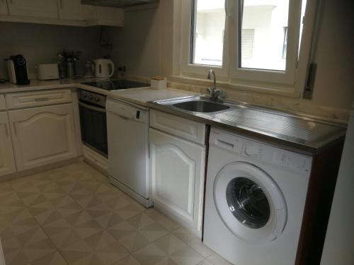 uma cozinha com máquina de lavar e pia em Casa do Algarve em Albufeira