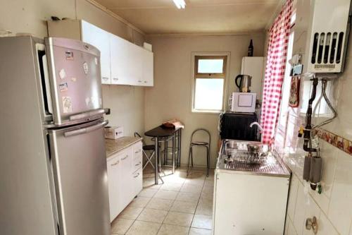 een keuken met een koelkast en een tafel bij Cabaña familiar in Cochrane
