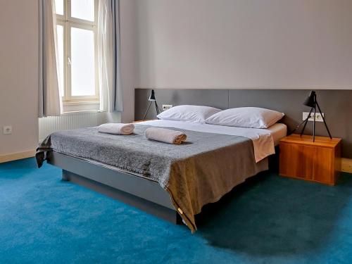 a bedroom with a large bed with two pillows on it at Apartments Cilindar in Zagreb