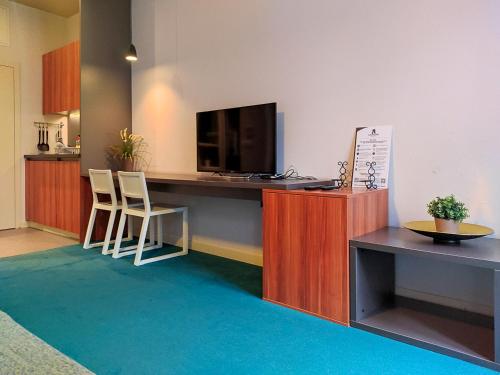 a room with a desk with a television and two chairs at Apartments Cilindar in Zagreb