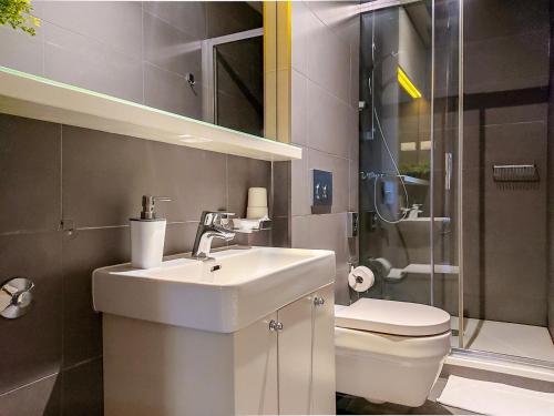 a bathroom with a sink and a toilet and a shower at Apartments Cilindar in Zagreb