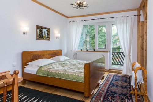 een slaapkamer met een bed en een raam bij Willa Żbikówka dom w Zakopanem in Zakopane
