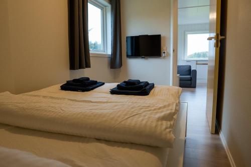sypialnia z łóżkiem z dwoma czarnymi ręcznikami w obiekcie Vollvaagen Apartments Smøla, boat included w mieście Smøla