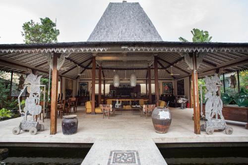 a pavilion with a table and chairs in it at Wayang Retreat in Canggu