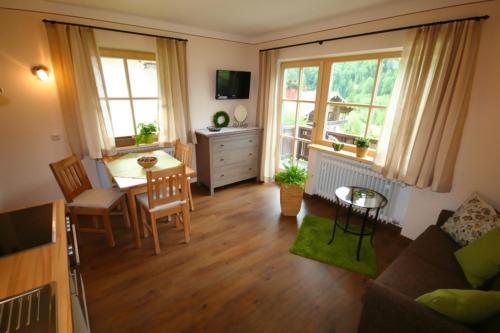 un soggiorno con tavolo e una sala da pranzo di Staller Hof a Ruhpolding