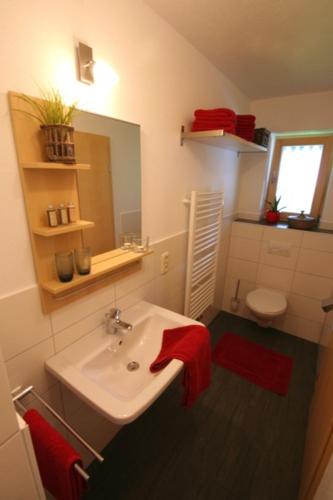 a bathroom with a white sink and a toilet at Staller Hof in Ruhpolding