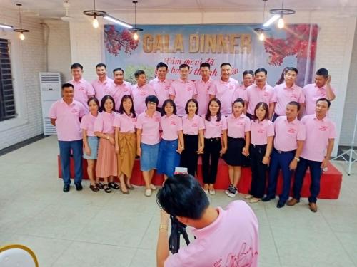 un gruppo di persone vestite di camicie rosa che posano per una foto di Mai Home Ninh Bình a Ninh Binh