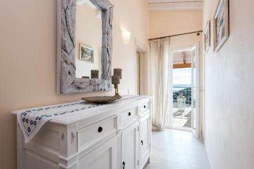 a bathroom with a white vanity and a mirror at Villa Frosso in Kalami