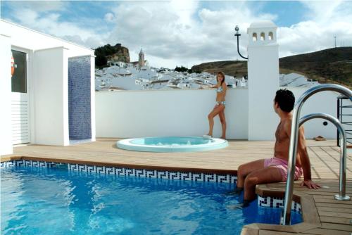 a woman standing on a wall next to a swimming pool at Apartamento María Mendoza in Ardales