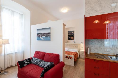 a living room with a red couch and a bed at Rooms Boutique Carducci in Trieste