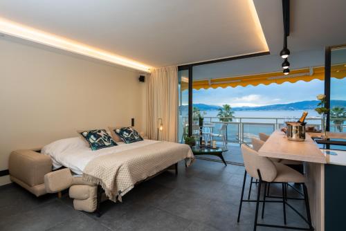 a bedroom with a bed and a balcony with a view at Palm croisette front de mer1 in Cannes